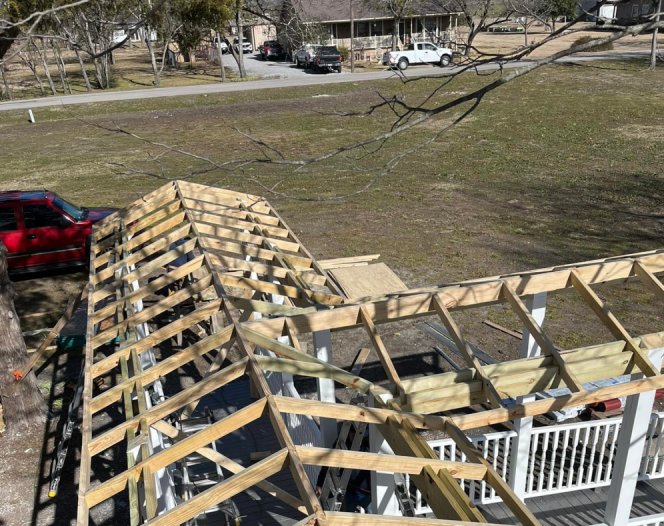 Roof framing exposed during a roof replacement, with the old decking removed